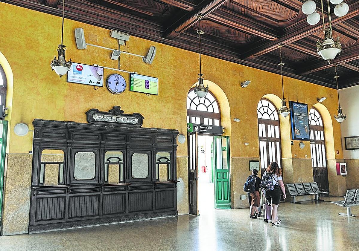 Pasajeros esperando en el vestíbulo de la estación de trenes, que será rediseñado y cuya cubierta será remodelada.