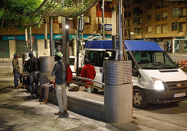 Temporeros de Lorca esperando ayer el transporte que los trasladará a una finca.