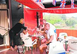 Un grupo de extranjeros brindan con sus cervezas en un bar de La Finca, en Algorfa.