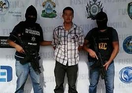 El arrestado, junto a dos policías hondureños.