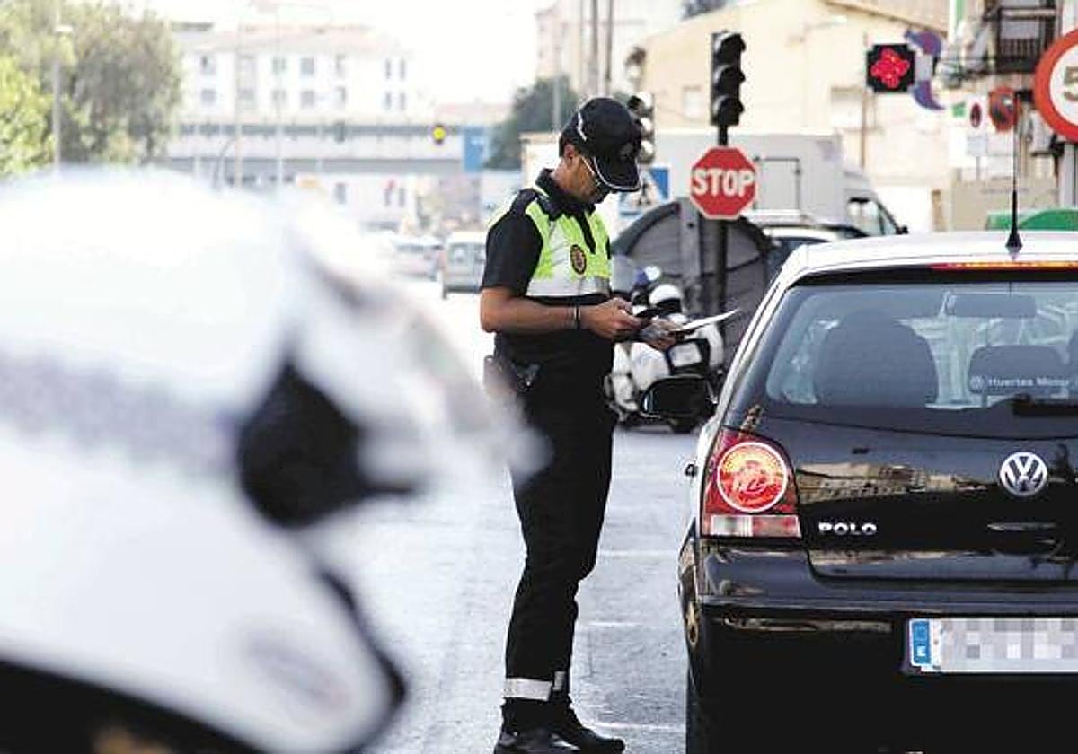 Un agente pone una multa de tráfico.