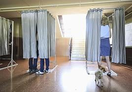 Votantes escogen sus papeletas antes de votar, en una imagen de archivo.