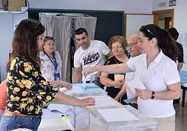 Varias personas en una mesa electoral.