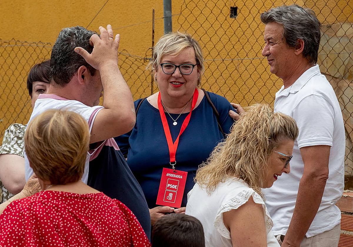 La candidata del PSOE a la alcaldía de Albudeite, Isabel Peñalver (centro), acompañada por compañeros de su partido, este domingo en la puerta del único colegio electoral que hay en el municipio.