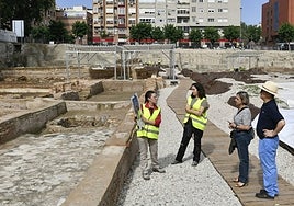 Los dos primeros visitantes reciben explicaciones sobre la calle Ñ de Alicia Hernández, ante la presencia de Irene González.