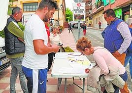 Una vecina firma el documento de los agricultores, ayer.