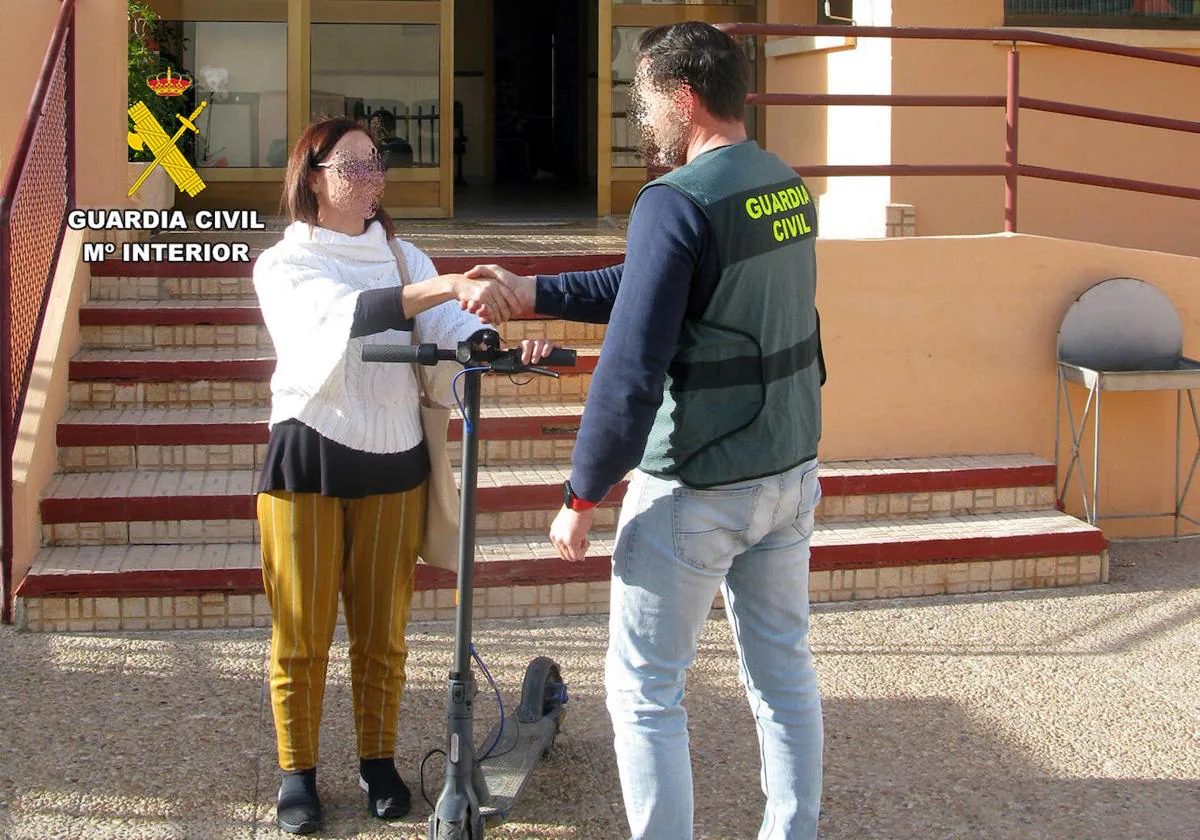 Un agente de la Guardia Civil devuelve uno de los patinetes sustraídos a su dueña.