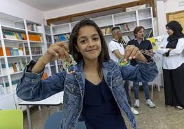 Omayma Bennouna sostiene sus pulseras mientras sus padres y el director del centro conversan detrás.