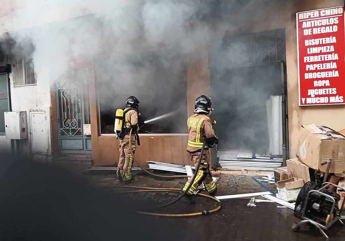 Los bomberos sofocando el incendio del bazar.