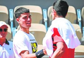 Carlos Alcaraz y Djokovic se saludan tras entrenar en una de las pistas de Roland Garros, cuando se disputaba la fase previa, el pasado 26 de mayo.