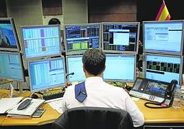 Agente de una operadora de fondos sigue una subasta de bonos para incluir en sus carteras.