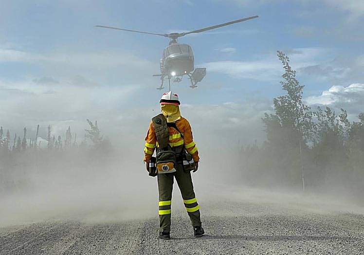 Uno de los bomberos de la Región de Murcia desplegados en Canadá, frente a un helicóptero.