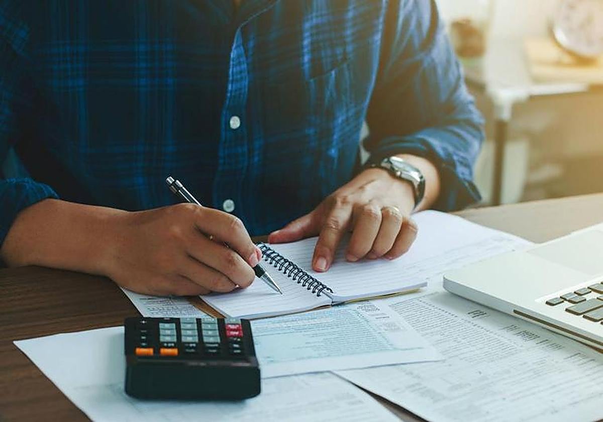 Un hombre hace cuentas con una calculadora.