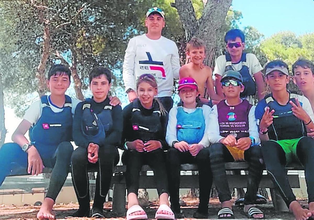 Regatistas de los dos conjuntos de la Región que competirán en el Nacional de optimist por equipos, con Andrés Palou, su entrenador.