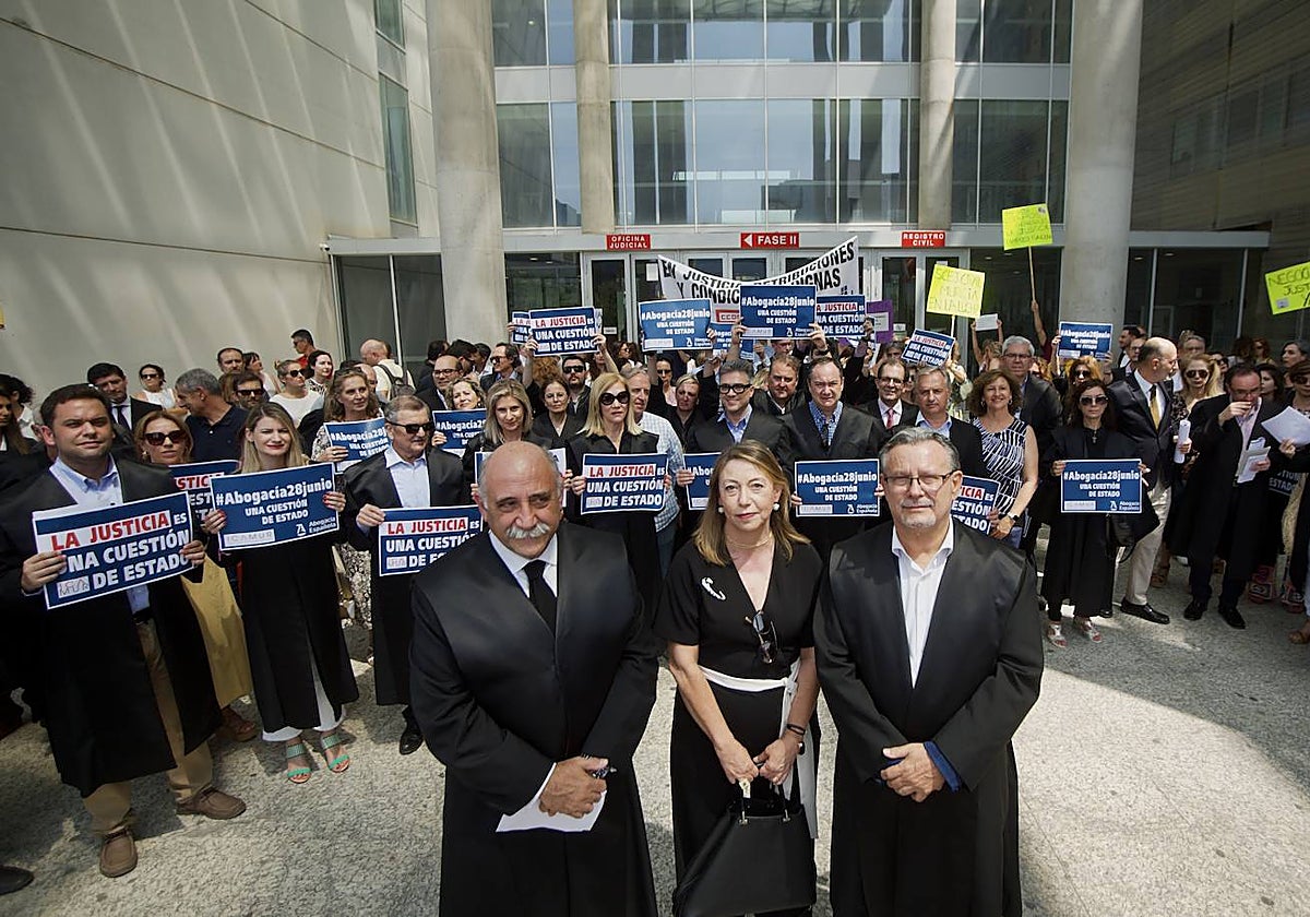Concentración de abogados, este martes, en Murcia. Detrás, protesta de funcionarios judiciales.