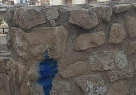 Pintada realizada con aerosol de color azul en la muralla medieval.