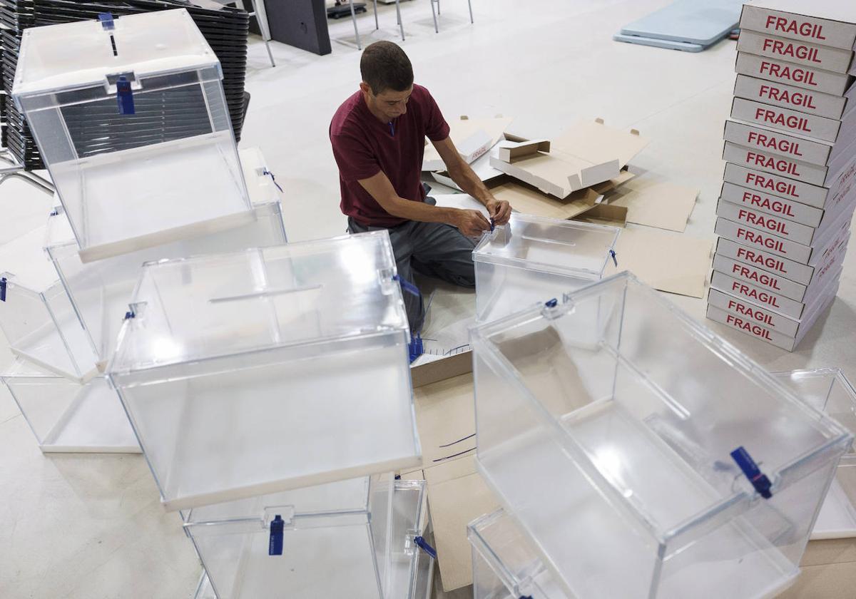 Un operario apila varias urnas en un colegio electoral, en una imagen de archivo.