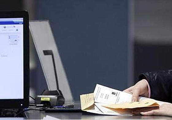 Una ciudadana recoge su voto por correo.