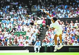 Carlos Alcaraz sirve en su partido de segunda ronda ante el francés Muller, ayer en la pista central del All England Club de Londres.