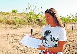María del Carmen Martínez, en su finca, con la carta que ha recibido de la Comunidad.