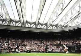 Carlos Alcaraz realiza un saque en la central de Wimbledon, este viernes ante Medvedev.