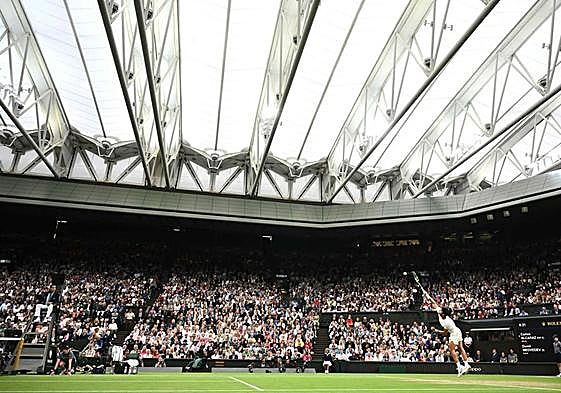 Carlos Alcaraz realiza un saque en la central de Wimbledon, este viernes ante Medvedev.