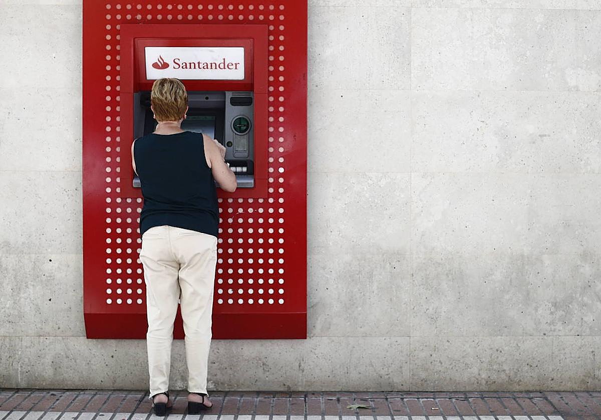 Una mujer sacando dinero del cajero, en una imagen de archivo.