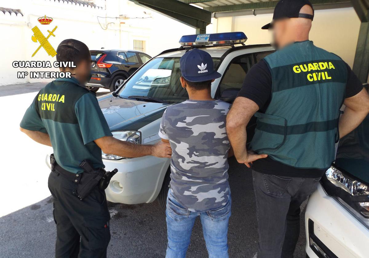 Dos agentes arrestan a uno de los responsables del robo.