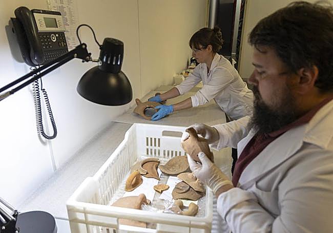 Adrián Baeza y Belén Madariaga revisan una de las cajas con material arqueológico.