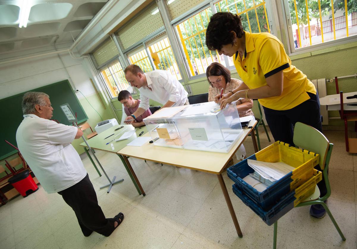 Una trabajadora entrega el voto por correo en un colegio de Murcia, este domingo.