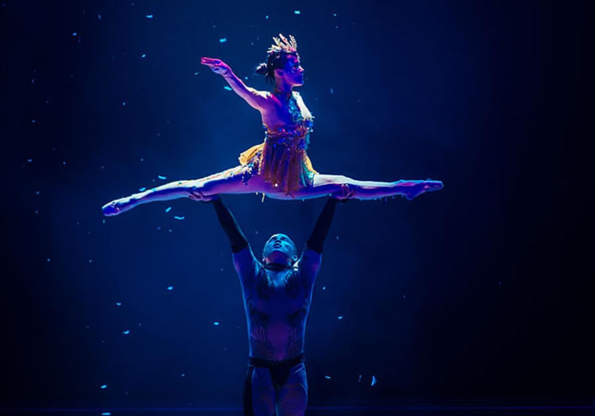 Dos artistas del espectáculo realizan un número acrobático.