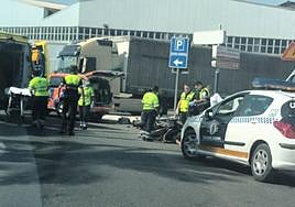 Los sanitarios atienden al motorista, que se encuentra tumbado en el suelo.