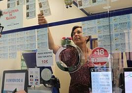 Una lotera coloca los décimos de la Lotería de Navidad en su administración.
