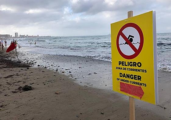 Bandera roja y cartel de advertencia, este jueves, en la playa de Levante.