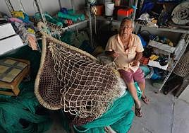 Manuel Ballesta, en su nave del Puerto de Mazarrón, remienda una red de pesca.