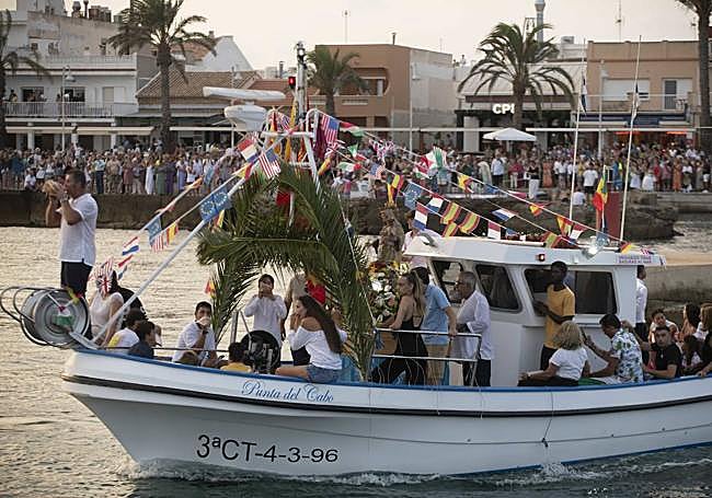 Un marinero hace sonar una caracola en la proa de la embarcación que porta a la Virgen del Mar, en Cabo de Palos.