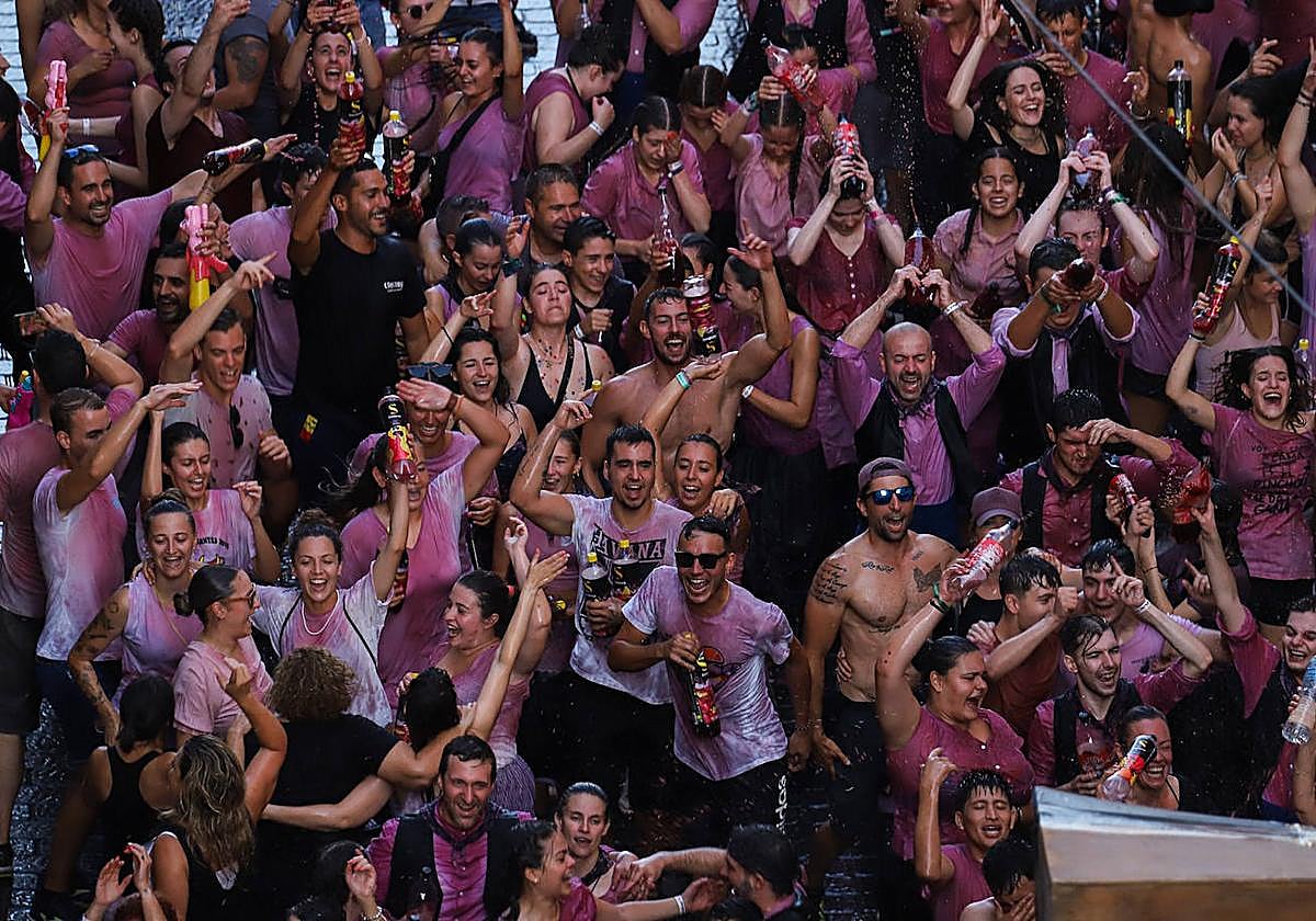 Cientos de asistentes teñidos de morado por el vino disfrutan en las calles de la localidad.