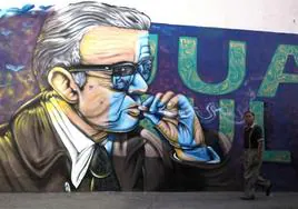 Tuxcacuesco. Un hombre pasa frente a un mural con una imagen del escritor mexicano Juan Rulfo, autor de 'Pedro Páramo'.