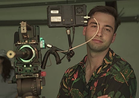 Imagen secundaria 1 - El director Pablo Riesgo, con el cartel de la película y una escena del rodaje en La Manga. 