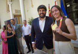 Eva Navarro muestra la medalla de campeona del mundo de fútbol femenino, durante su encuentro con López Miras, este martes.