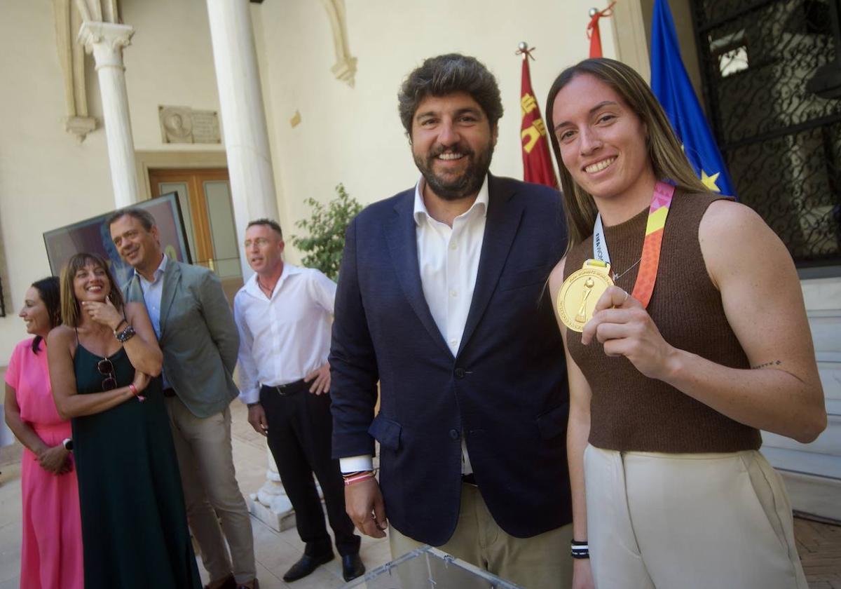 Eva Navarro muestra la medalla de campeona del mundo de fútbol femenino, durante su encuentro con López Miras, este martes.