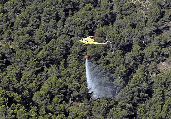 Un helicóptero realiza una descarga de agua.