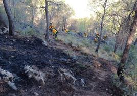 Una brigada trabaja en la extinción del incendio registrado en el Valle. A la derecha, el fuego sale por la ventana de un piso en Murcia.