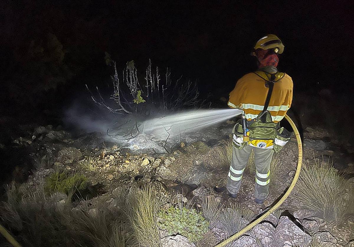 Un bombero apaga los restos del incendio que comenzó por un rayo este viernes en Sierra Espuña.