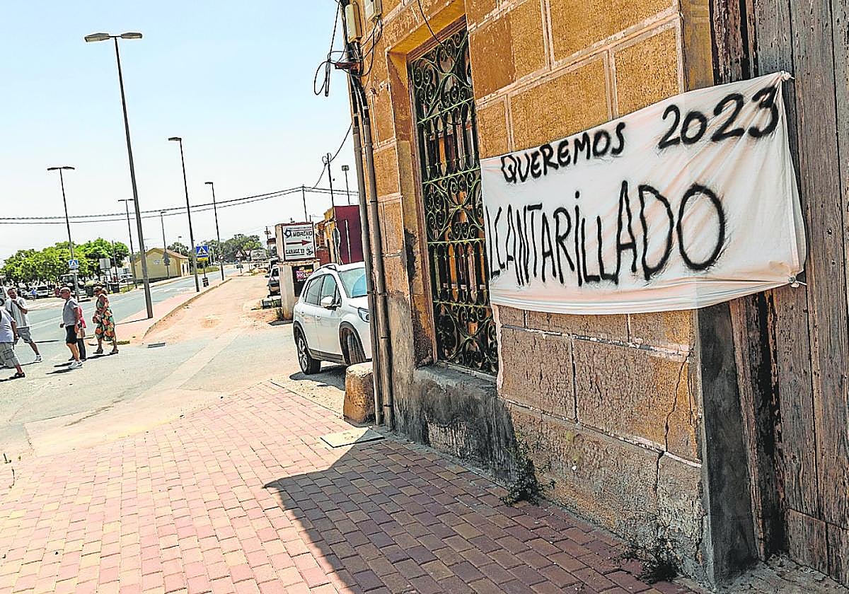Una pancarta con el lema 'Queremos alcantarillado', en la fachada de una casa de La Guía.