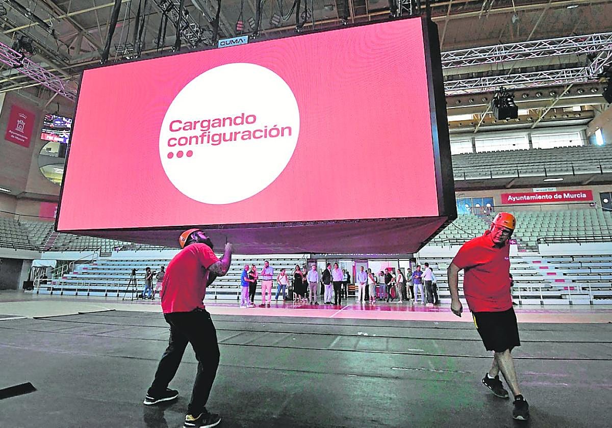 Dos operarios programando el nuevo videomarcador, ayer en el Palacio.