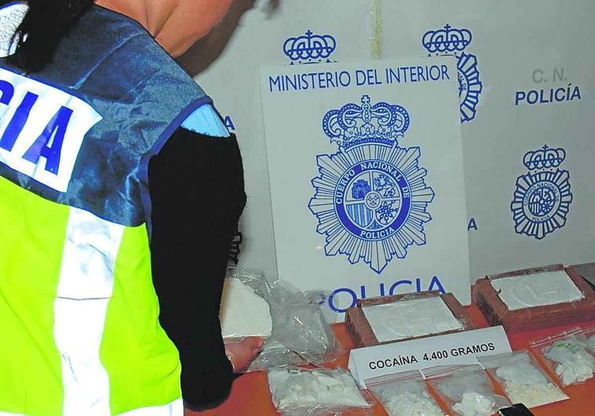 Un agente de la Policía Nacional custodia uno de los alijos de cocaína intervenidos en la etapa que se indaga.