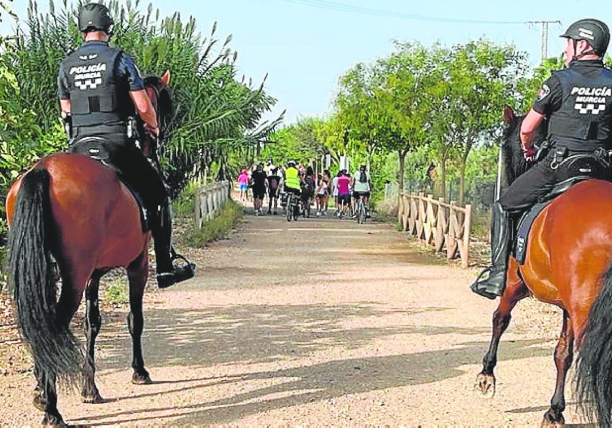 Dos policías, tras un grupo de participantes en la caminata.