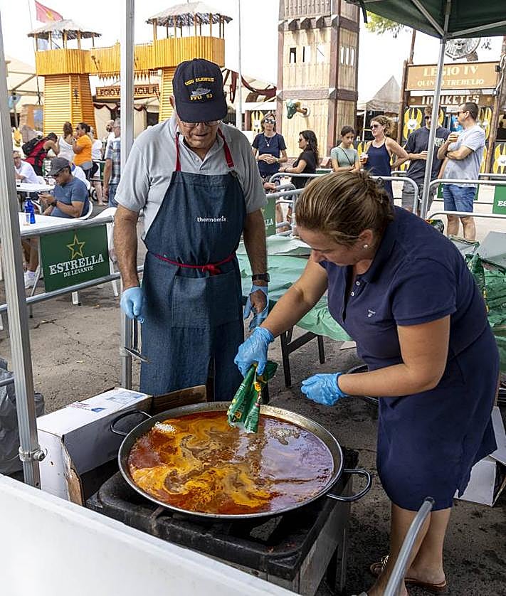 Imagen secundaria 2 - Uno de los momentos del acto de la Destrucción de Sagunto, celebrado en el escenario instalado en el puerto. |El grupo de música Elure, durante su actuación en el campamento festero, frente a su público. | Miembros del colectivo Saneamiento a Niños Afectados por Chernobyl (Sanac) preparan un caldero solidario.