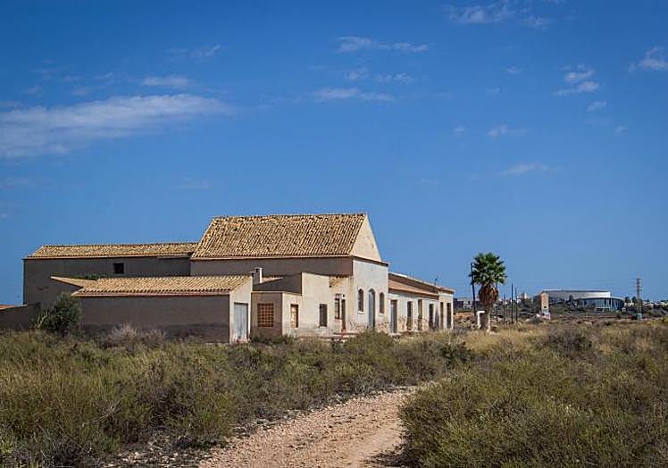 Antigua casa agrícola de La Hoya. Al fondo, el Auditorio Internacional.